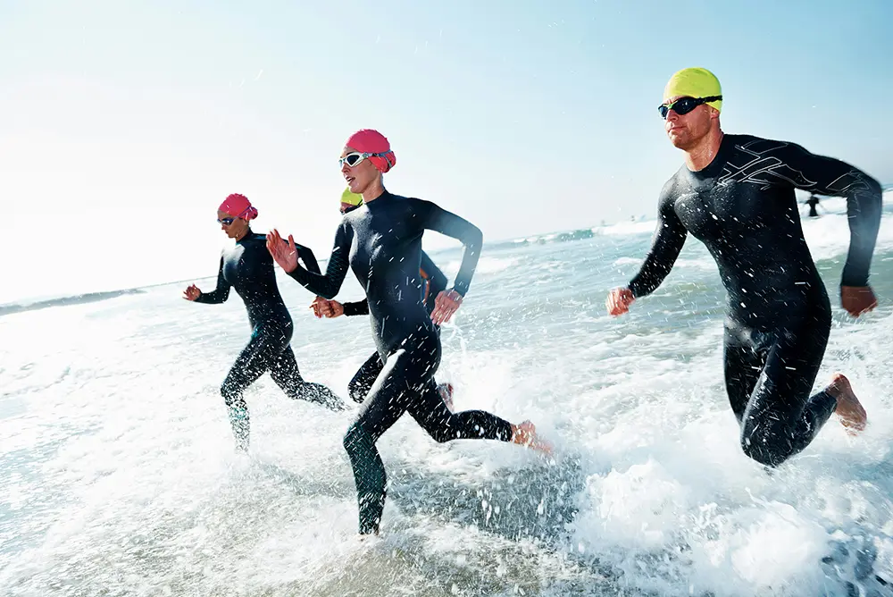 Group of swimmers running into the water